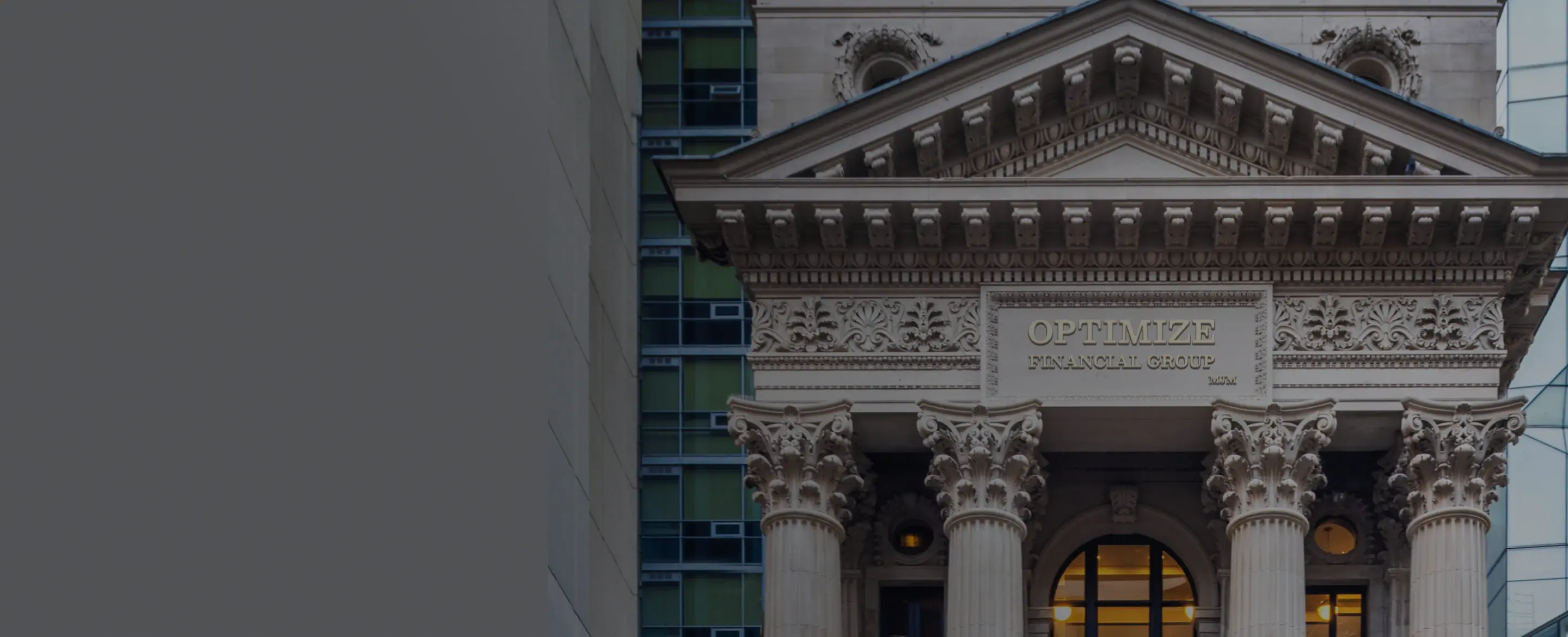 Close-up of a historic building façade with ornate stone carvings and the words ‘OPTIMIZE FINANCIAL GROUP’ engraved above the entrance.