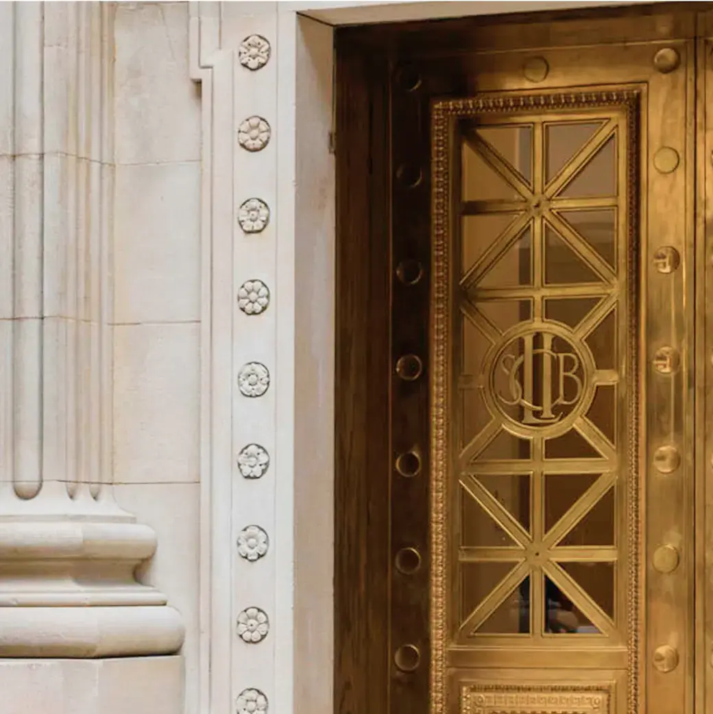 Ornate golden door set into a white stone building with decorative details