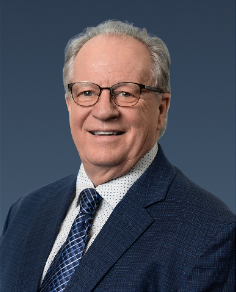 Professional portrait of a man in a navy suit, smiling.