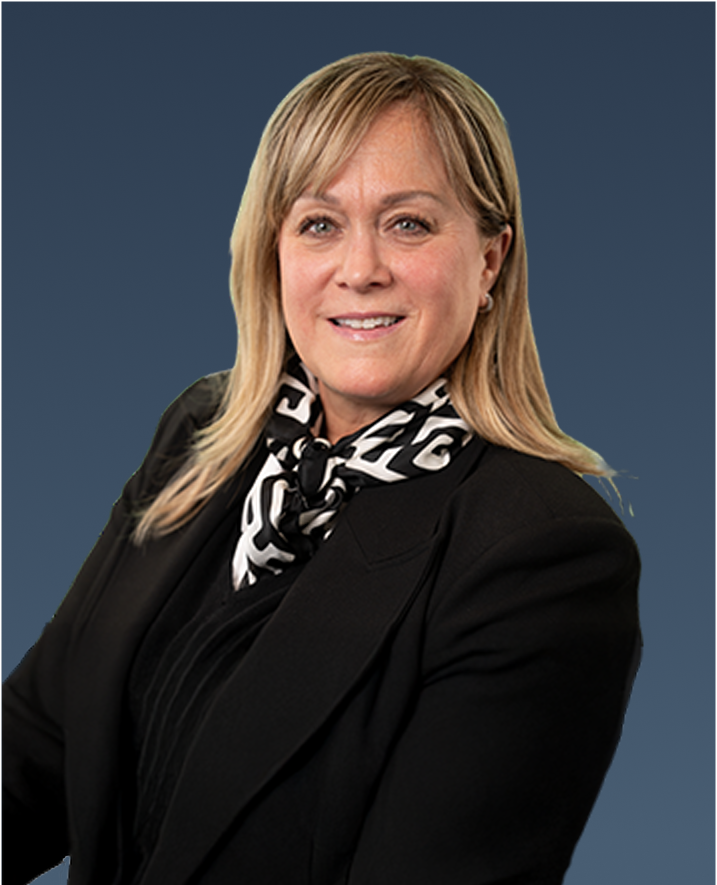 Professional portrait of a blonde woman with shoulder-length hair, wearing a black blazer and patterned scarf.