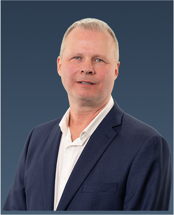 Professional portrait of a man with light hair in a navy blazer and pale shirt, looking forward.